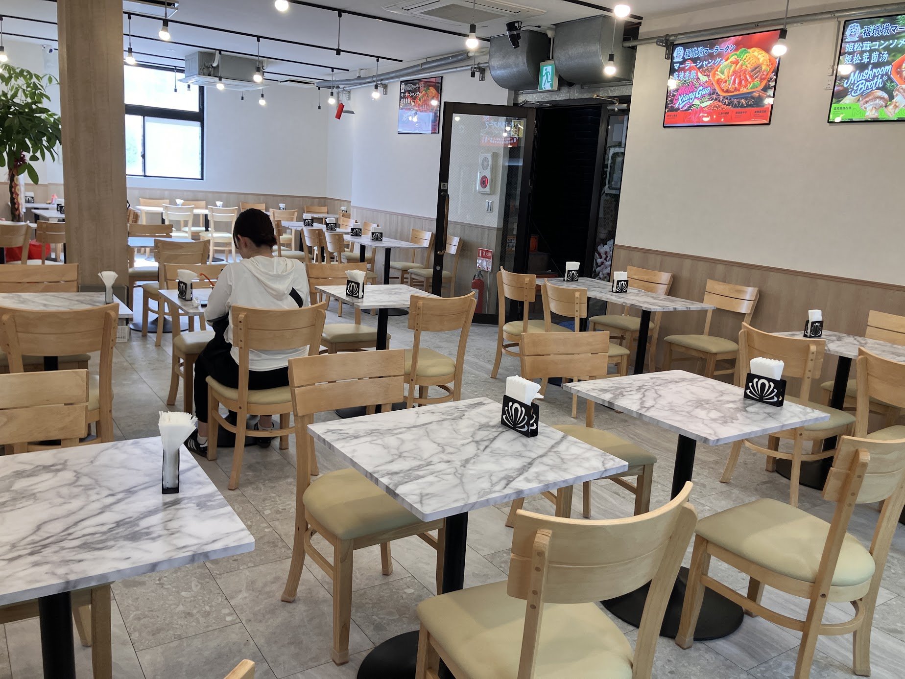 福墩墩麻辣湯 町屋店の店内、マーブル調テーブルの客席